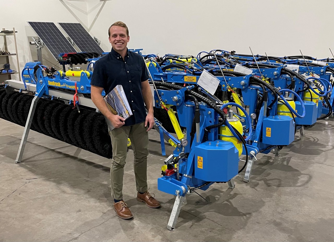 Operations manager Jordon Tillmann stands in front of the first SunBrush mobil TrackFlex machines delivered. 